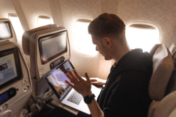 Man working on laptop on plane